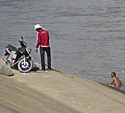 'A Man, having a bath in the Tonle Sap River in Phnom Penh' by Asienreisender